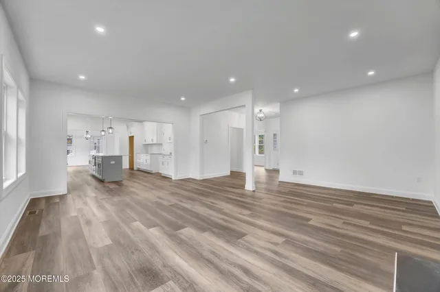 an empty room with wooden floor and fireplace