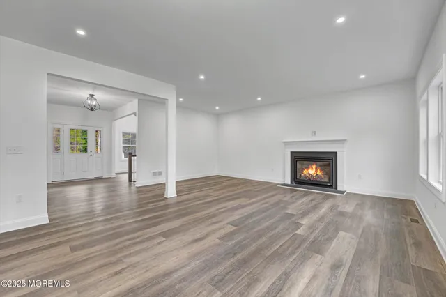 a kitchen with stainless steel appliances granite countertop hardwood floor sink stove and white cabinets with wooden floor