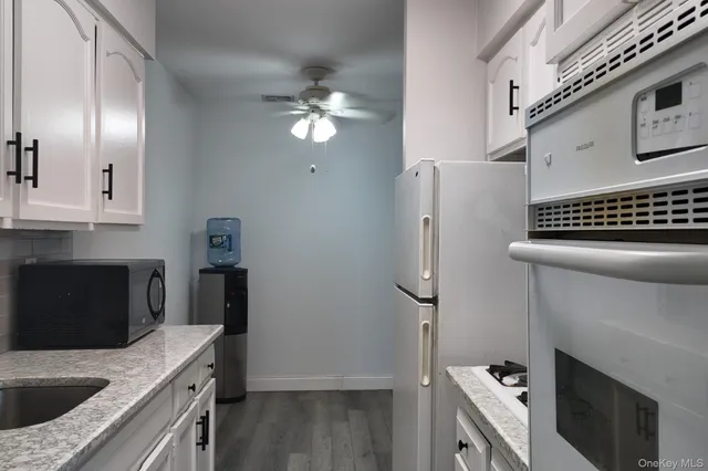 a kitchen with granite countertop a sink stove and refrigerator