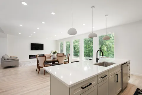 a kitchen with stainless steel appliances granite countertop a sink cabinets and wooden floor