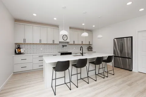a kitchen with sink a large window and couch