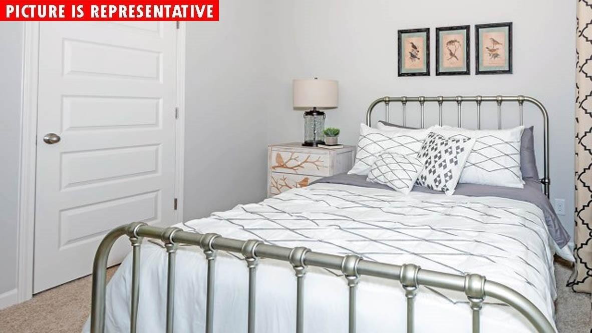 115 Flame Azalea Court Locust, NC 28097 - Photo 16 of 22 a bedroom with a bed and a table in it