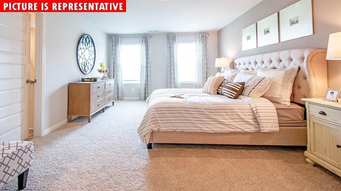 115 Flame Azalea Court Locust, NC 28097 - Photo 19 of 22 a bedroom with a bed and a chandelier