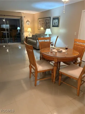 a living room with furniture a lamp and dining table