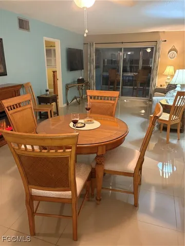 a dining room with furniture and a floor to ceiling window