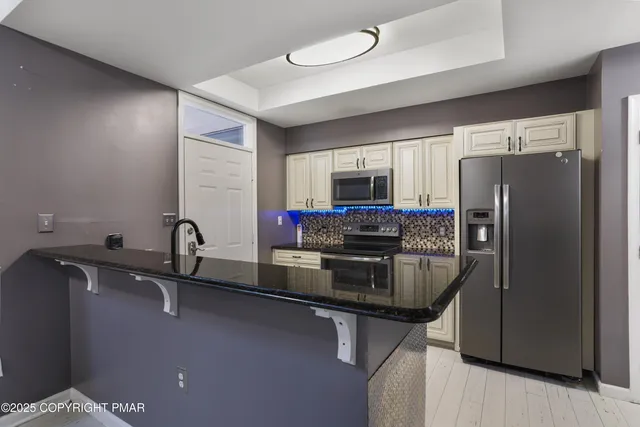a kitchen with a refrigerator a sink and cabinets