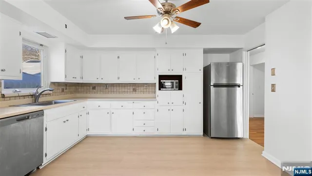 a view of a big room with wooden floor and windows