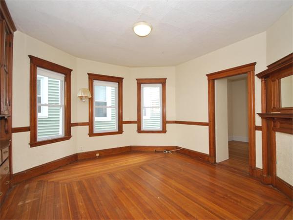 21 Taft Street Boston, MA 02125 - Photo 4 of 9 an empty room with wooden floor and windows