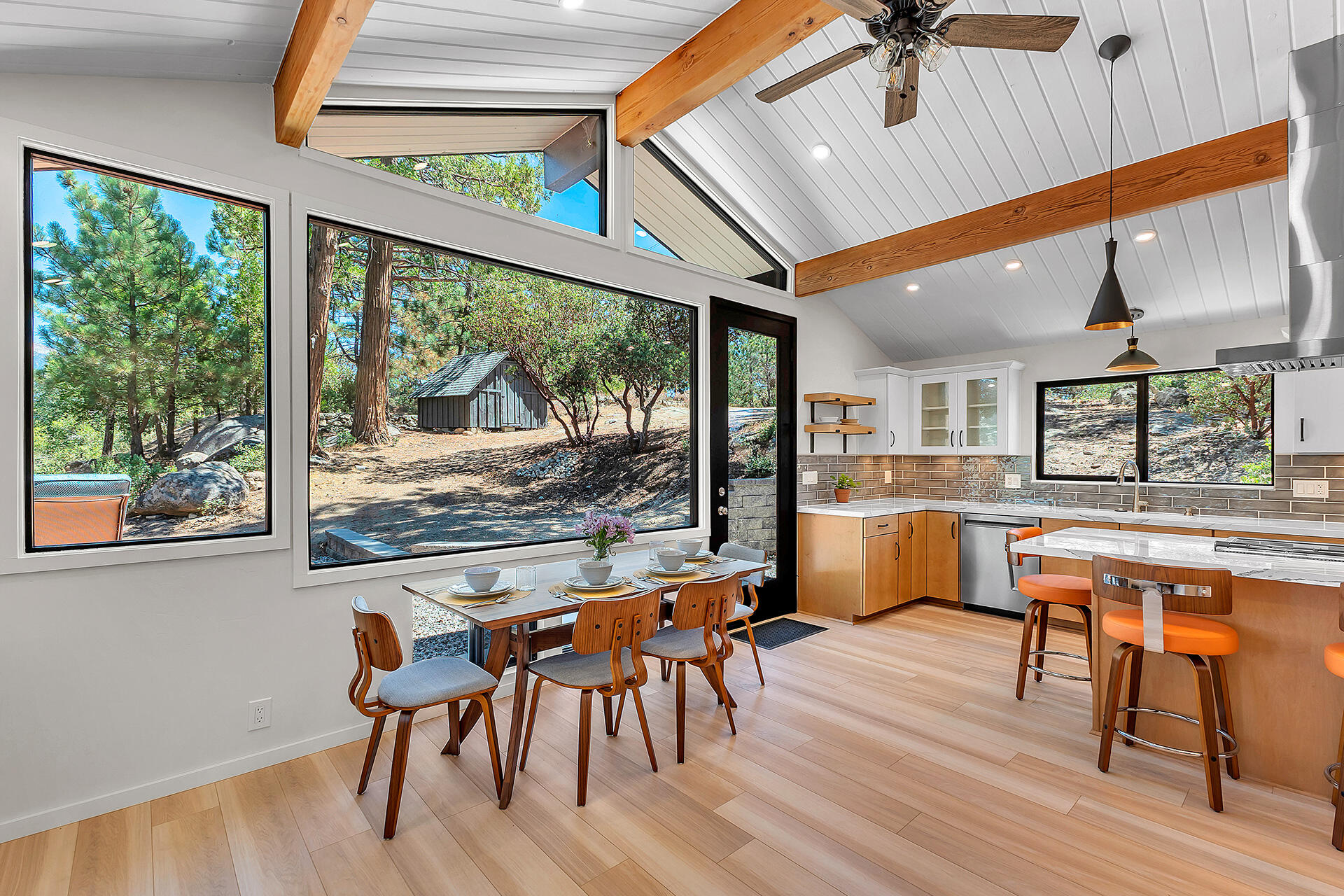 52600 Double View Drive Idyllwild, CA 92549 - Photo 28 of 75 a dining room with wooden floor a chandelier a glass table and chairs