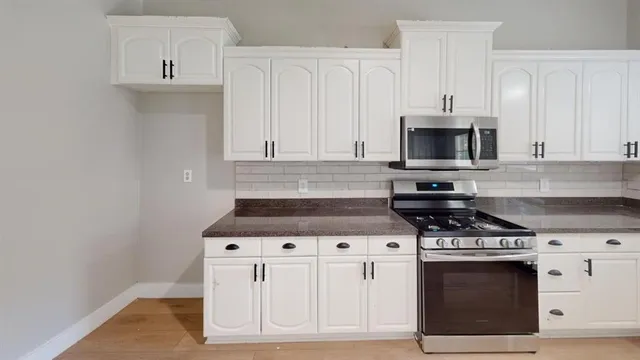 a stove top oven sitting inside of a kitchen