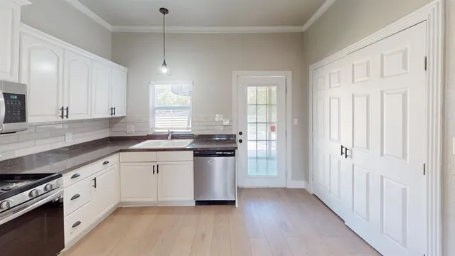 a kitchen with granite countertop white cabinets and white appliances