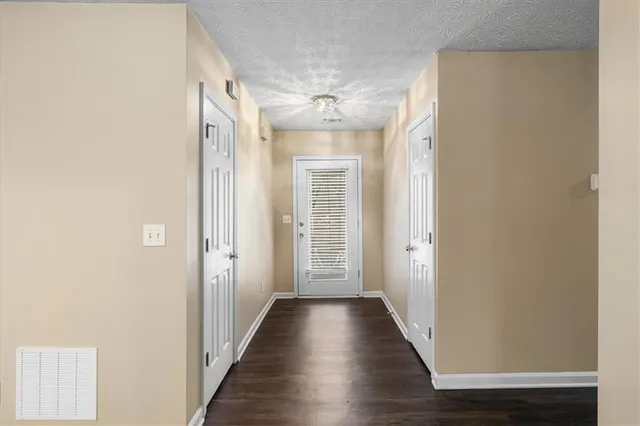 a view of a hallway with wooden floor and closet