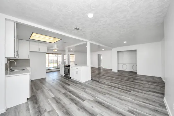 a view of a kitchen with wooden floor and a refrigerator