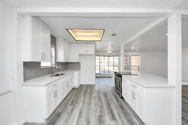 a kitchen with a sink stove and cabinets