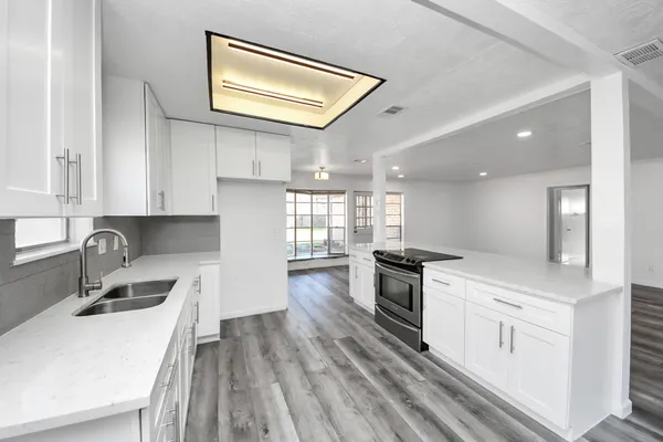 a kitchen with a sink stove and white cabinets
