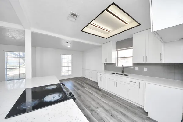 a kitchen with granite countertop a stove sink and cabinets