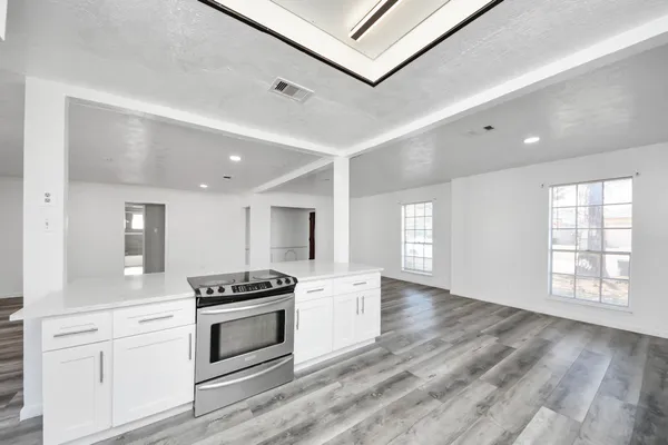 a kitchen with granite countertop a stove and cabinets