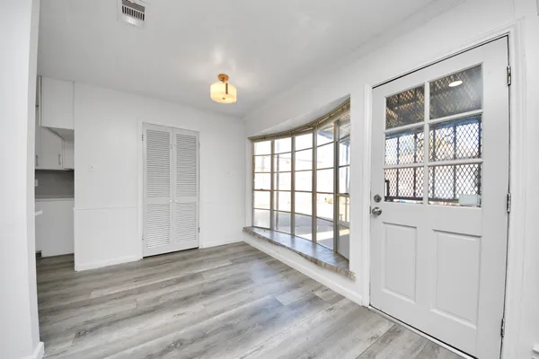 an empty room with wooden floor and windows