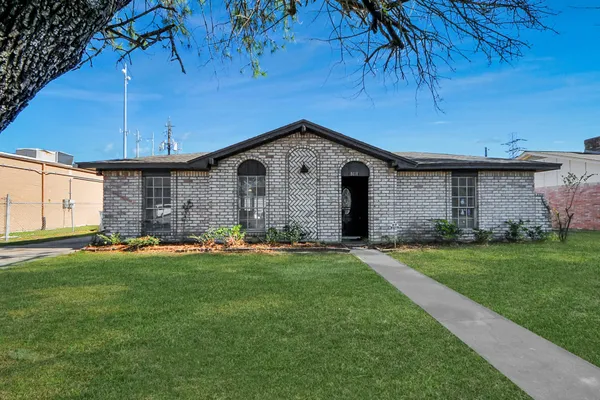 a front view of a house with a garden and yard