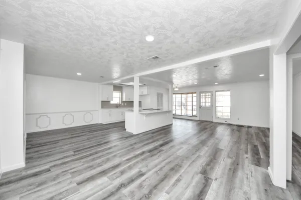 a view of empty room with wooden floor and windows