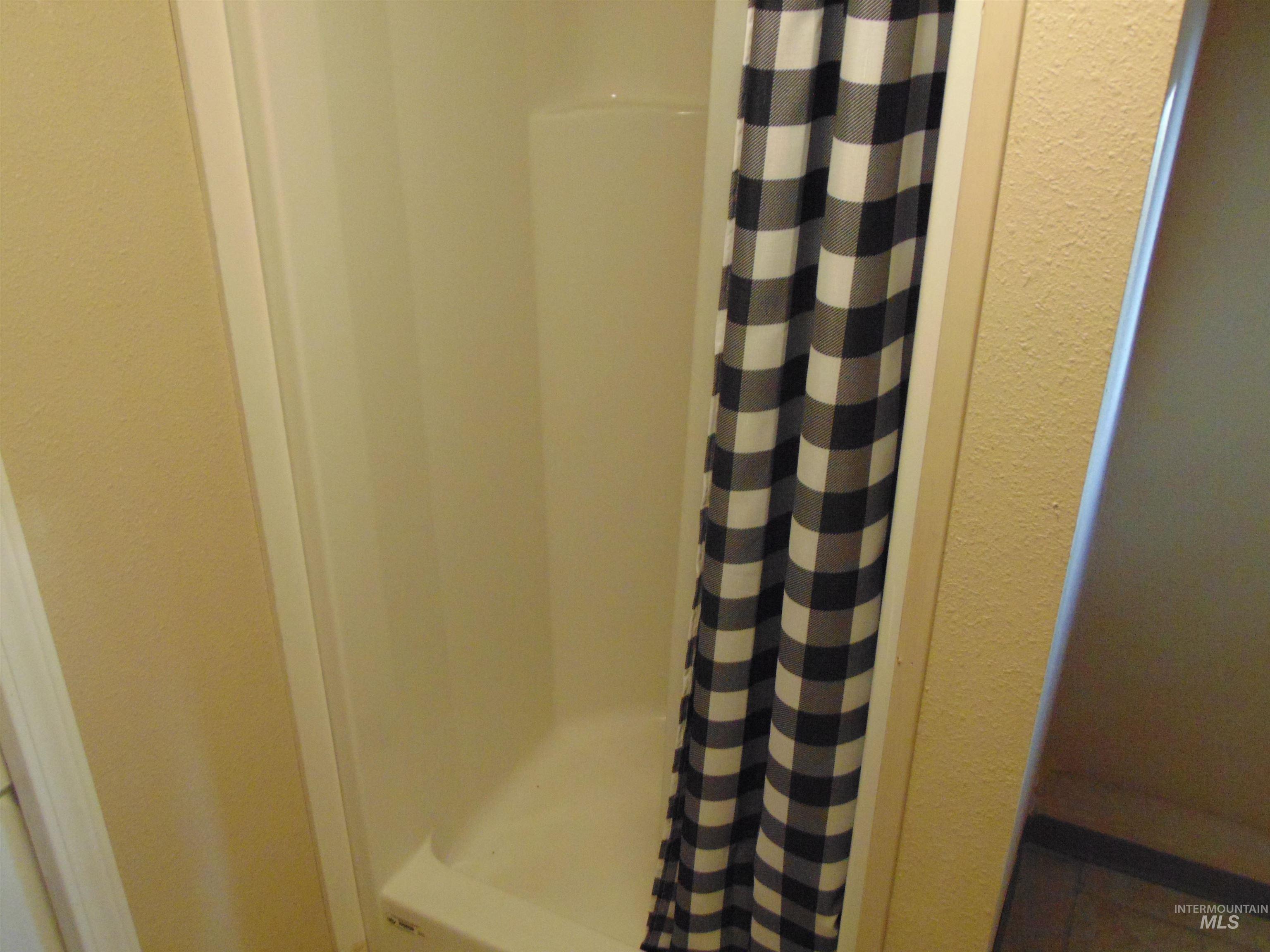 1825 7th Avenue Lewiston, ID 83501 - Photo 19 of 26 Bathroom featuring a shower with shower curtain and a textured wall