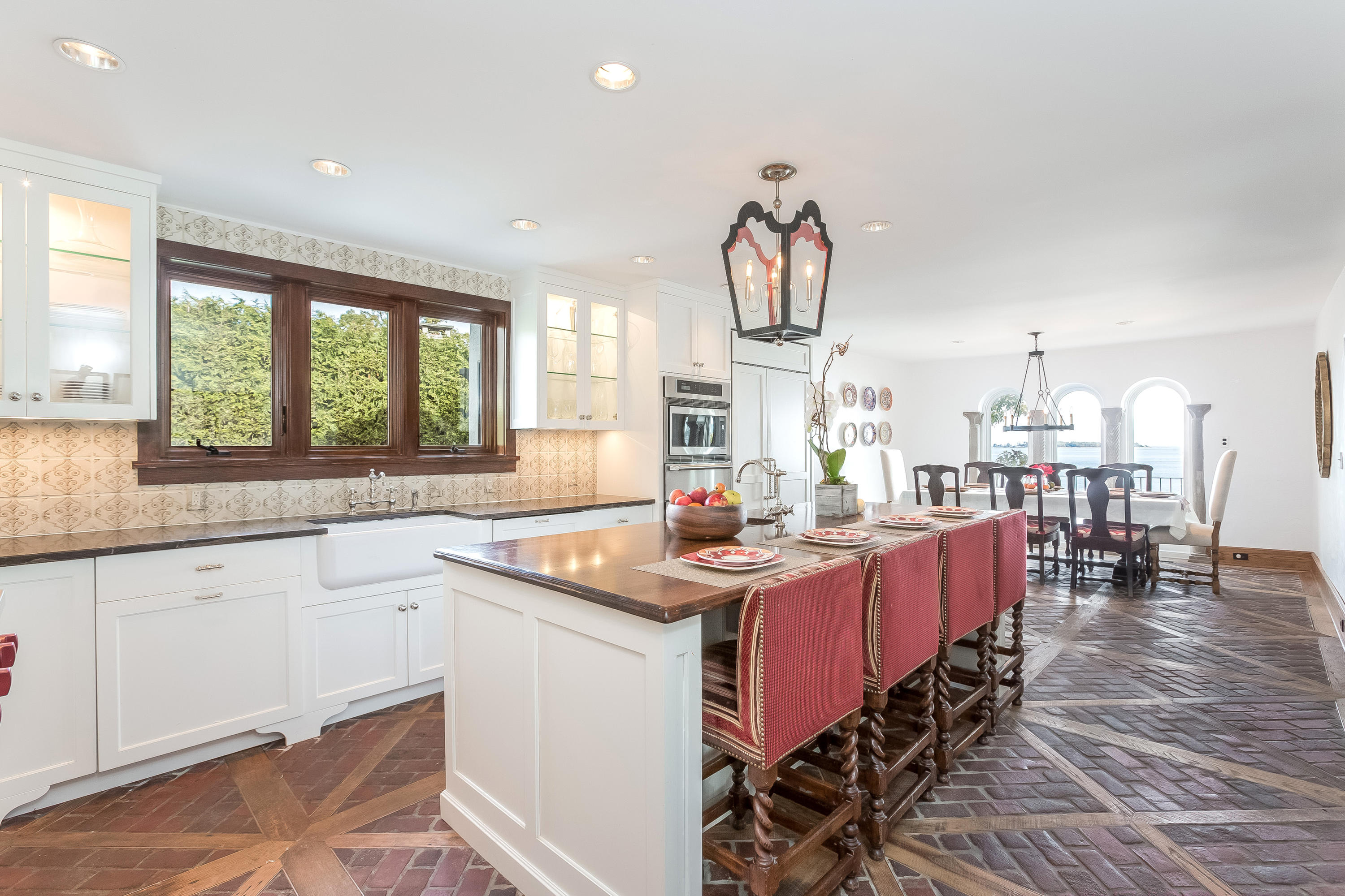 8 Woodland Road Norwalk, CT 06854 - Photo 12 of 44 a kitchen with stainless steel appliances granite countertop a sink dishwasher a stove a dining table and chairs with wooden floor