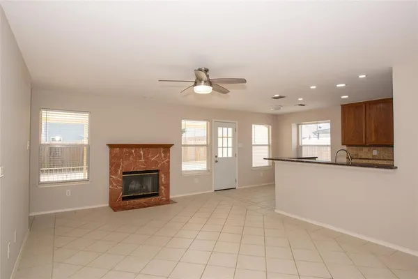 an empty room with windows and fireplace