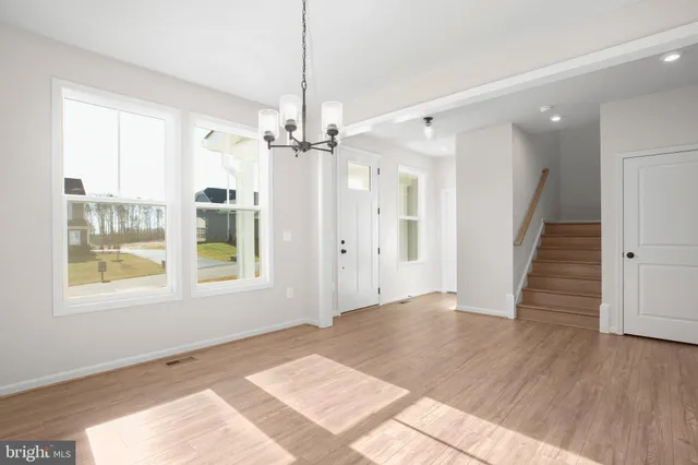 a view of a room with wooden floor and a ceiling fan
