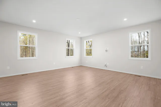 a view of kitchen with kitchen island wooden floors and stainless steel appliances
