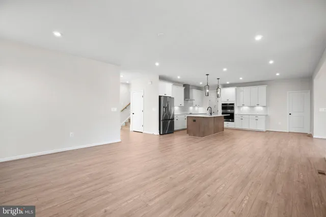 a view of a kitchen with a sink and dishwasher a refrigerator with wooden floor