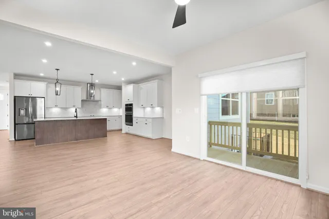 a large kitchen with stainless steel appliances kitchen island granite countertop a large counter top a stove a refrigerator and cabinets