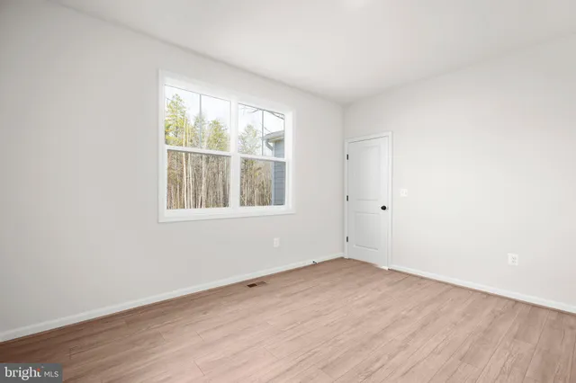 a view of a small space with wooden floor and a small window