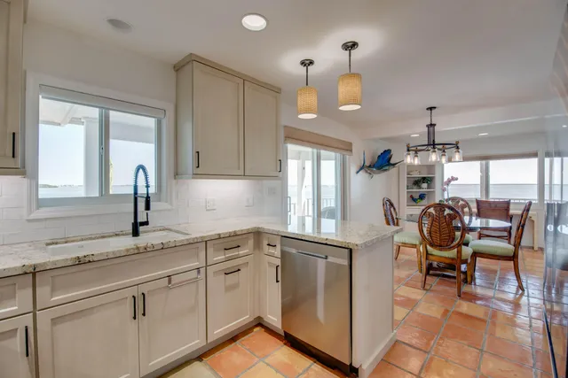 a kitchen with stainless steel appliances granite countertop a sink dishwasher a stove and a microwave oven with cabinets