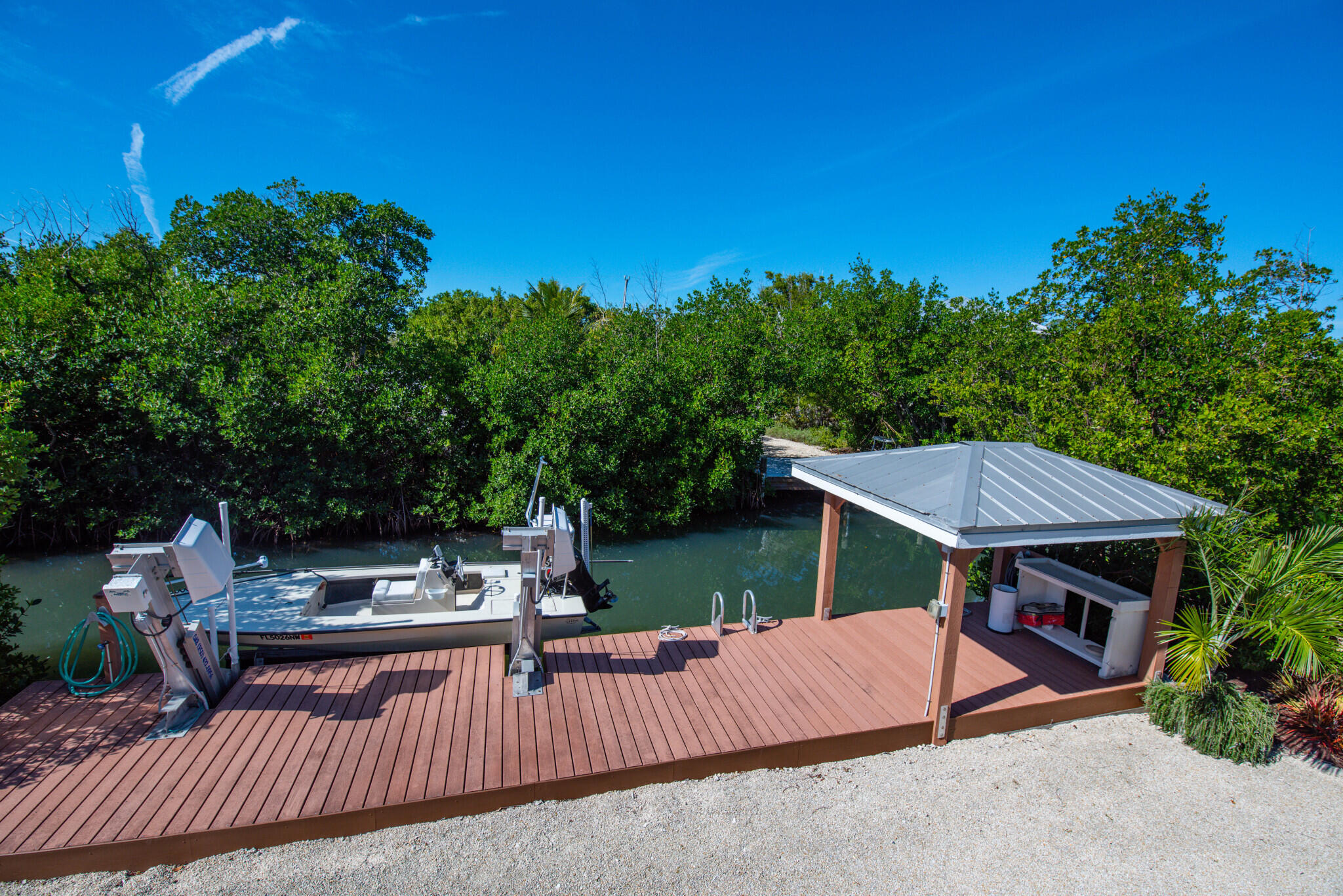 1176 Thatch Lane Cudjoe, FL 33042 - Photo 37 of 41 a view of a patio with couches table and chairs with plants and trees