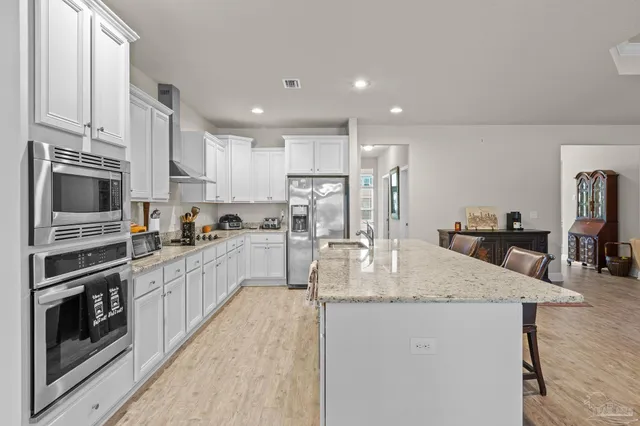 a kitchen with stainless steel appliances granite countertop a stove top oven a sink and dishwasher