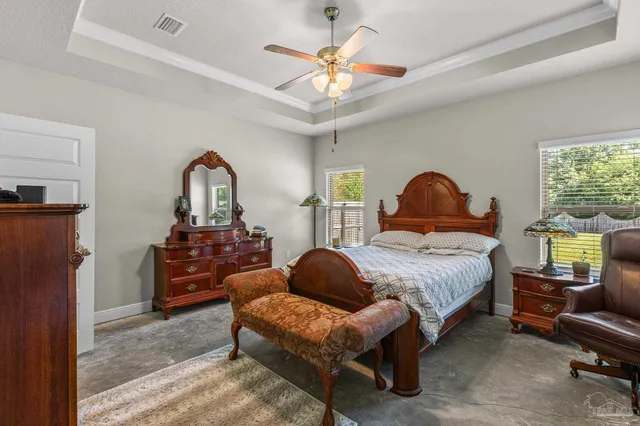 a bedroom with a bed a couch and a chandelier