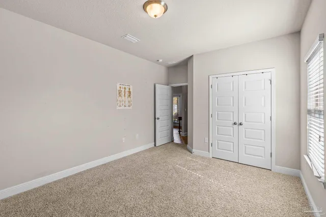 an empty room with windows and closet