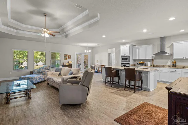 a living room filled with furniture kitchen view and a wooden floor