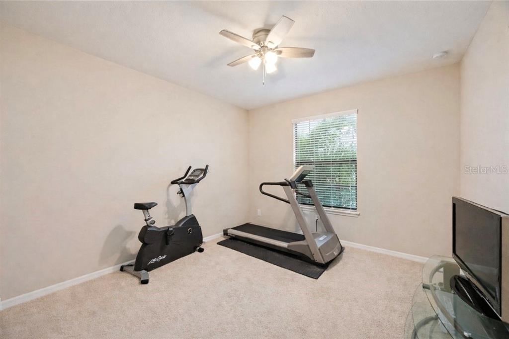 13608 Messina Loop, Unit 202 Bradenton, FL 34211 - Photo 23 of 73 a room with gym equipment and a flat screen tv