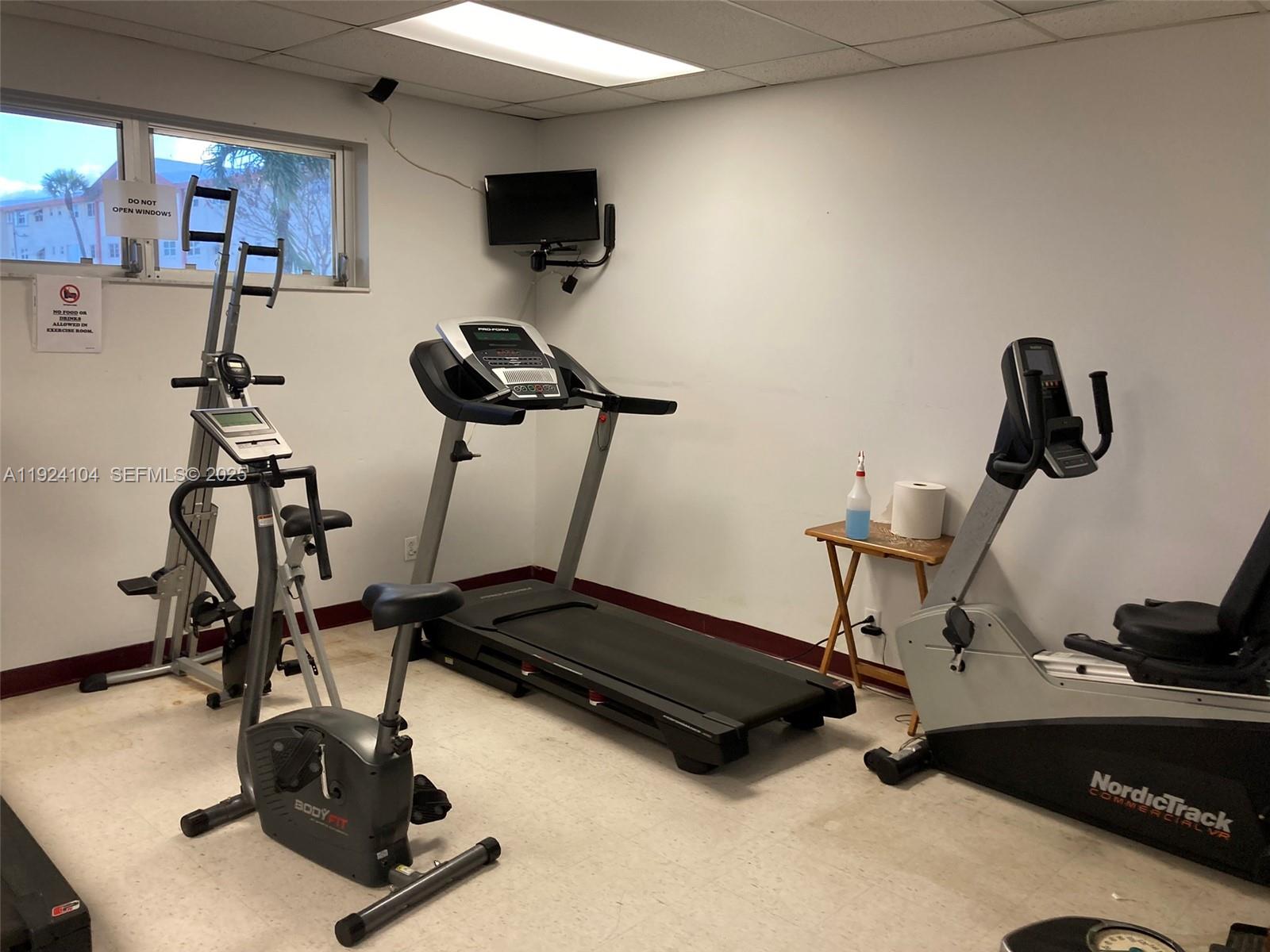 5300 Washington Street, Unit N117 Hollywood, FL 33021 - Photo 76 of 99 a room with gym equipment and a flat screen tv