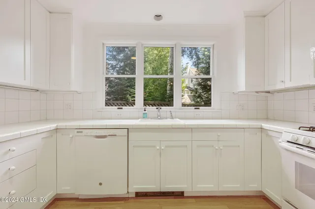 a kitchen with granite countertop white cabinets and white appliances