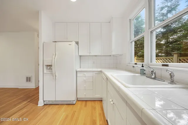 a view of a kitchen with a sink and dishwasher with wooden floor