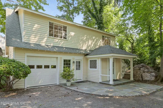 a front view of a house with a garden