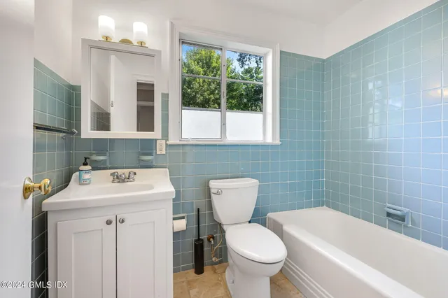 a bathroom with a sink toilet and window