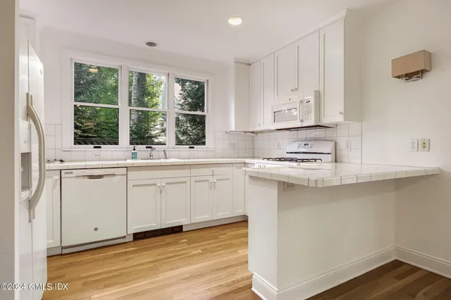 a kitchen with stainless steel appliances white cabinets and a window