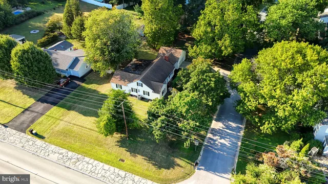an aerial view of a residential houses with yard