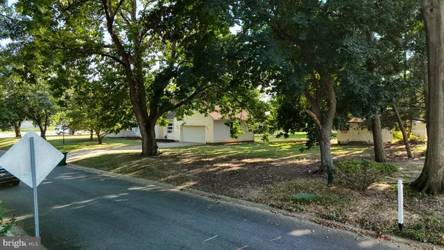 a front view of house with yard and trees around