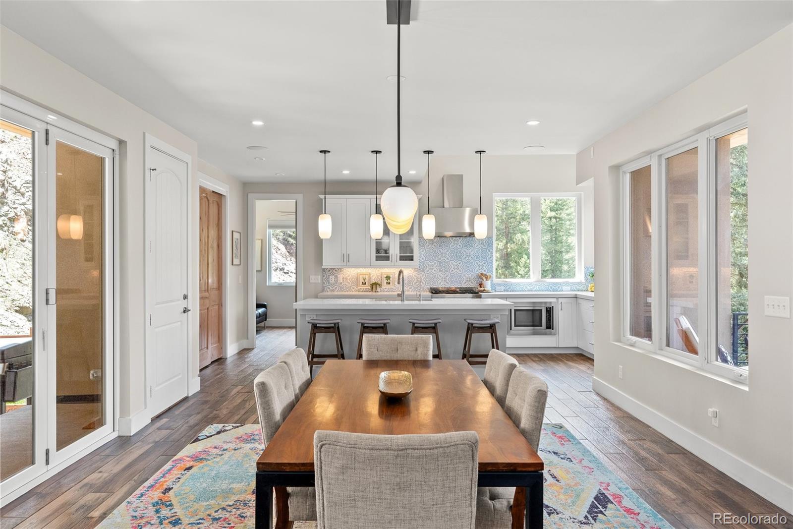 9218 South Turkey Creek Road Morrison, CO 80465 - Photo 15 of 44 a kitchen with a table chairs refrigerator and sink