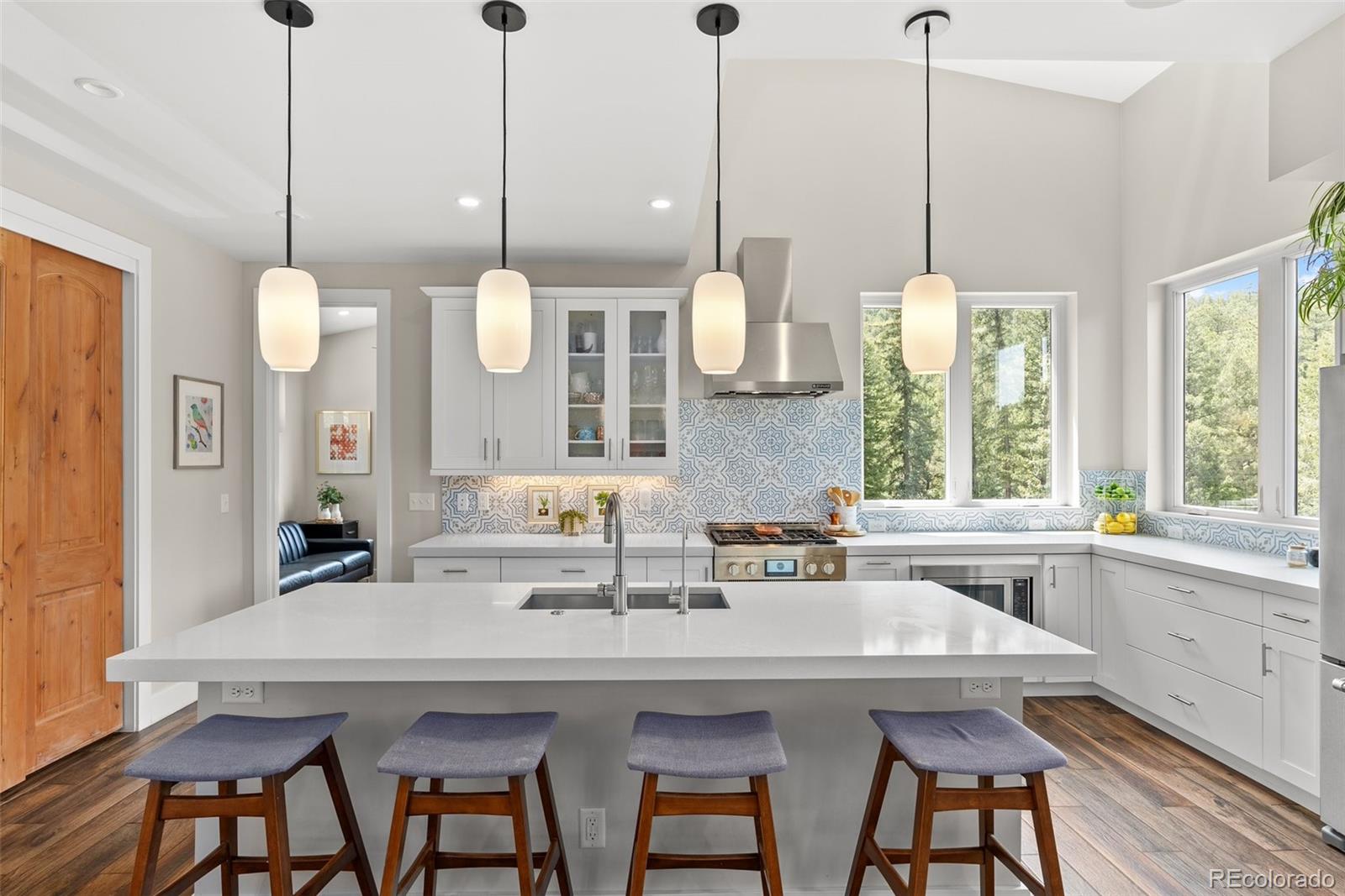 9218 South Turkey Creek Road Morrison, CO 80465 - Photo 19 of 44 a kitchen with stainless steel appliances kitchen island a table and chairs