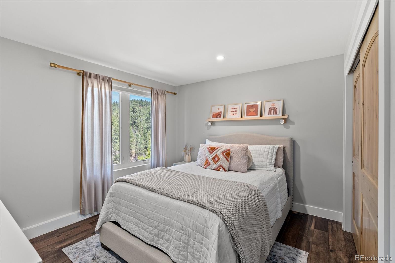 9218 South Turkey Creek Road Morrison, CO 80465 - Photo 26 of 44 a bed sitting in a bedroom next to a window